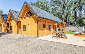 une cabane en bois avec une aire de jeux en face de celle-ci dans l'établissement Stunning Home In Pobierowo With Kitchen, à Pobierowo