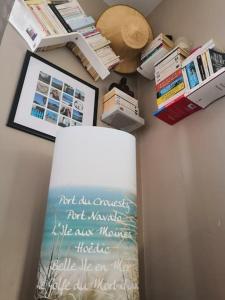 una bacheca con libri e un cartello su un muro di logement avec jardin de bord Mer PORT NAVALO ad Arzon