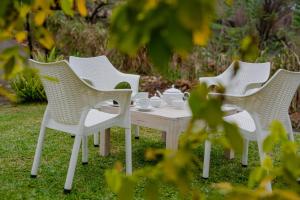 a group of white chairs and a table with cups on it at Casa Del Sol - Luxury Villa in Bolepe
