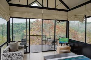 a room with a living room with a tv and some windows at Casa Del Sol - Luxury Villa in Bolepe