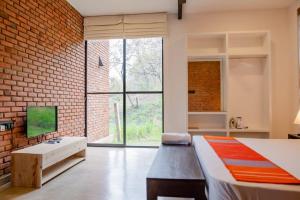 a bedroom with a bed and a brick wall at Casa Del Sol - Luxury Villa in Bolepe