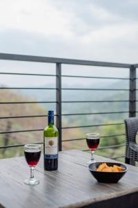 een fles wijn en twee glazen op een houten tafel bij Casa Del Sol - Luxury Villa 
