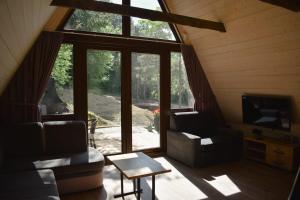 a living room with a large window in a cabin at Przystań nad Sanem z widokiem na góry i rzekę in Tyrawa Solna