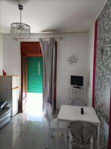 een woonkamer met een tafel en stoelen en een raam bij Butterfly House in Castellammare di Stabia
