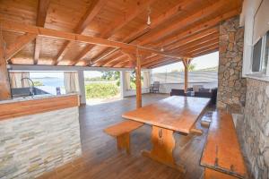 a dining room with a wooden table and a stone wall at House Romano in Neviđane