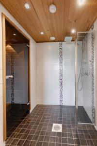 y baño con ducha y puerta de cristal. en Ellivuori Suite with Sauna and Balcony, en Sastamala