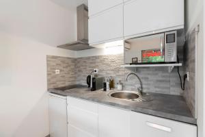 a kitchen with a sink and a microwave at Appartement 2 pièces au calme proche Martinez avec parking privé in Cannes