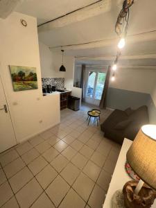 a living room with a couch and a kitchen at 8-Gîte 5 personnes avec piscine in Saint-Aubin-de-Nabirat