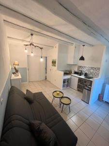 a living room with a couch and a kitchen at 8-Gîte 5 personnes avec piscine in Saint-Aubin-de-Nabirat