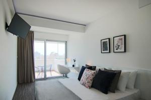 een witte woonkamer met een bank en een tafel bij Phaedrus Living: Luxury Suite Nicosia 508 in Nicosia