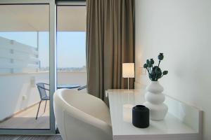 een witte vaas met bloemen op een tafel in een kamer bij Phaedrus Living: Luxury Suite Nicosia 508 in Nicosia