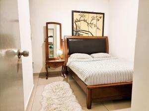 Schlafzimmer mit einem Bett und einem Spiegel in der Unterkunft Mossy Forest Family Retreat, Kea Farm Brinchang in Brinchang