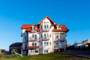 a white building with a red roof at VIPABO SolneSPA - Sauna, Grota Solna, Łaźnia parowa in Niechorze