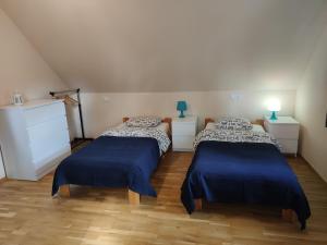 - 2 lits dans une chambre avec des draps bleus dans l'établissement Kraska Dom Wakacyjny w Sercu Puszczy Białowieskiej, à Białowieża