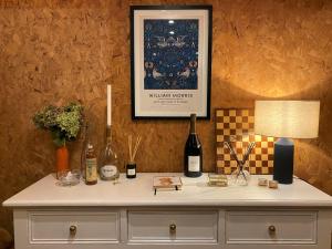 a table with bottles of wine and a lamp at Knus boshuisje middenin de natuur in Doldersum