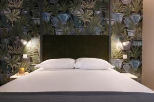 un letto con due cuscini e una parete con piante di Cactus Apartment, by Bolhão Residences a Porto