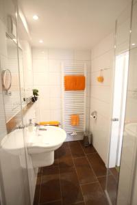 a white bathroom with a sink and a shower at Hotel Schmidt am Markt in Meppen