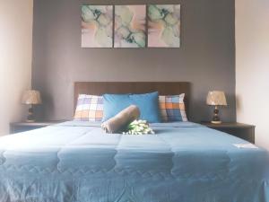 a large bed with blue sheets and two lamps at FRA Dreams @ Swiss Garden Resort Residences in Kuantan