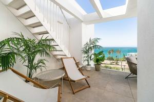 balcone con tavolo, sedie e vista sull'oceano di 71-Beachfront, brand new luxury penthouse Benalmádena a Benalmádena