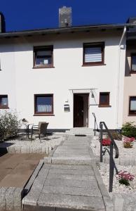 a white building with a pathway in front of it at Family House in Kappeln