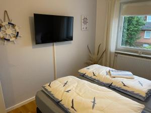 two beds in a room with a flat screen tv at Family House in Kappeln