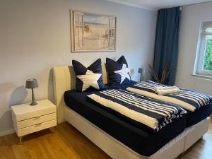 Schlafzimmer mit einem Bett mit blauen und weißen Kissen in der Unterkunft Family House in Kappeln