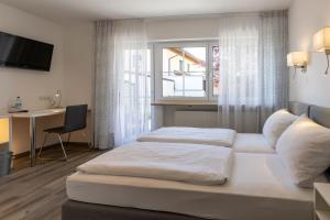 ein Hotelzimmer mit 2 Betten und einem Fenster in der Unterkunft Gästehaus Guggenberger in Höhenkirchen-Siegertsbrunn