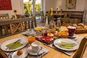 a wooden table with food and drinks on it at Gästehaus Guggenberger in Höhenkirchen-Siegertsbrunn