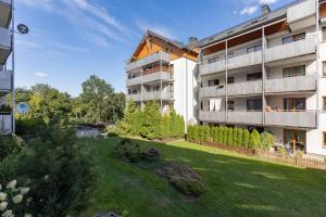 an apartment building with a lawn in front of it at Warsaw Bemowo Apartment with Balcony by Renters in Warsaw