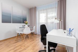 um quarto branco com uma mesa, cadeiras e uma secretária em Warsaw Bemowo Apartment with Balcony by Renters em Varsóvia