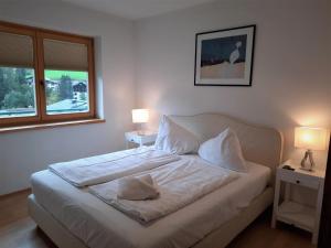 a bedroom with a bed with two lamps and a window at Apartment Bella Vista in Bad Kleinkirchheim
