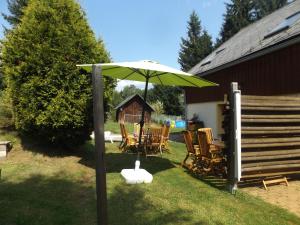 a green umbrella in a yard with chairs and a table at Holiday Home in Lampertice with Swimming Pool in Lampertice