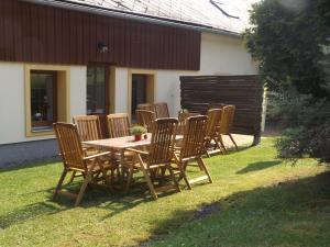 a group of chairs around a wooden table in a yard at Holiday Home in Lampertice with Swimming Pool in Lampertice