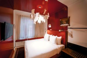 een rode kamer met een bed en een televisie bij The Highlander in Amsterdam