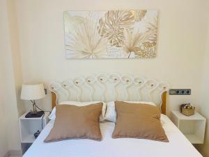 una camera con un letto bianco con due cuscini di Soleado Albir a Albir