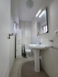 a white bathroom with a sink and a toilet at ÁTICO octava planta cerca de Murcia con vistas a la sierra. in Alcantarilla