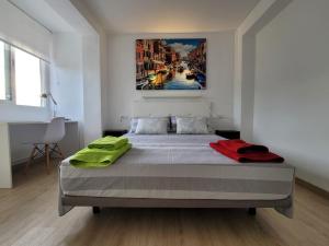 1 dormitorio con 1 cama con una pintura en la pared en ÁTICO octava planta cerca de Murcia con vistas a la sierra., en Alcantarilla