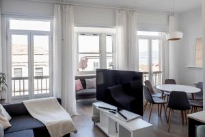 un soggiorno con divano e TV di Casa MIMOSA Vigo a Vigo