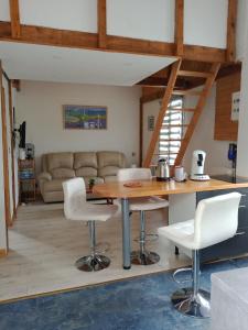 een keuken en een woonkamer met een tafel en stoelen bij Chalet du Sanglier in Rancennes