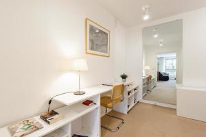 ein weißes Büro mit einem Schreibtisch und einem Spiegel in der Unterkunft Luxury Living in Saint Germain in Paris