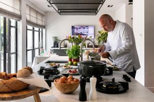 a chef preparing a meal in a kitchen at Boutique Hotel Villa Kranenbergh in Bergen