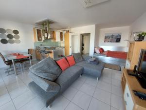 uma sala de estar com um sofá e uma cozinha em Tower Apartment with private terrace next to UNO em Viena