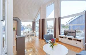 ein Wohnzimmer mit einem Tisch, einem TV und einigen Fenstern in der Unterkunft 2 Bedroom Nice Home In Krems Ii-warderbrck in Göls