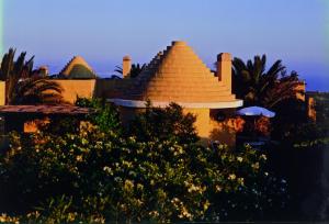 a building with a pyramid roof in a yard at Hotel Ta' Cenc & Spa in Sannat
