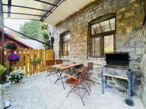 a patio with a table and chairs and a fireplace at Apartment Carol private Yard with barbeque and parking in Sinaia