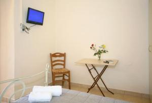 a bedroom with a bed and a table and a chair at On The Beach Apartments in Hora Sfakion