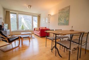 ein Wohnzimmer mit einem Tisch und Stühlen in der Unterkunft Viktoria B42 by Arosa Holiday in Arosa