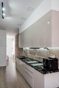 a kitchen with white cabinets and a black counter top at Casa MIMOSA Vigo in Vigo