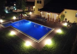 una piscina con luci in cortile di notte di Agriturismo Casa Chiara a Latina
