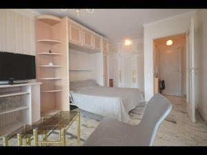 um quarto com uma cama, uma mesa e uma televisão em Nice studio near the beach em Cannes